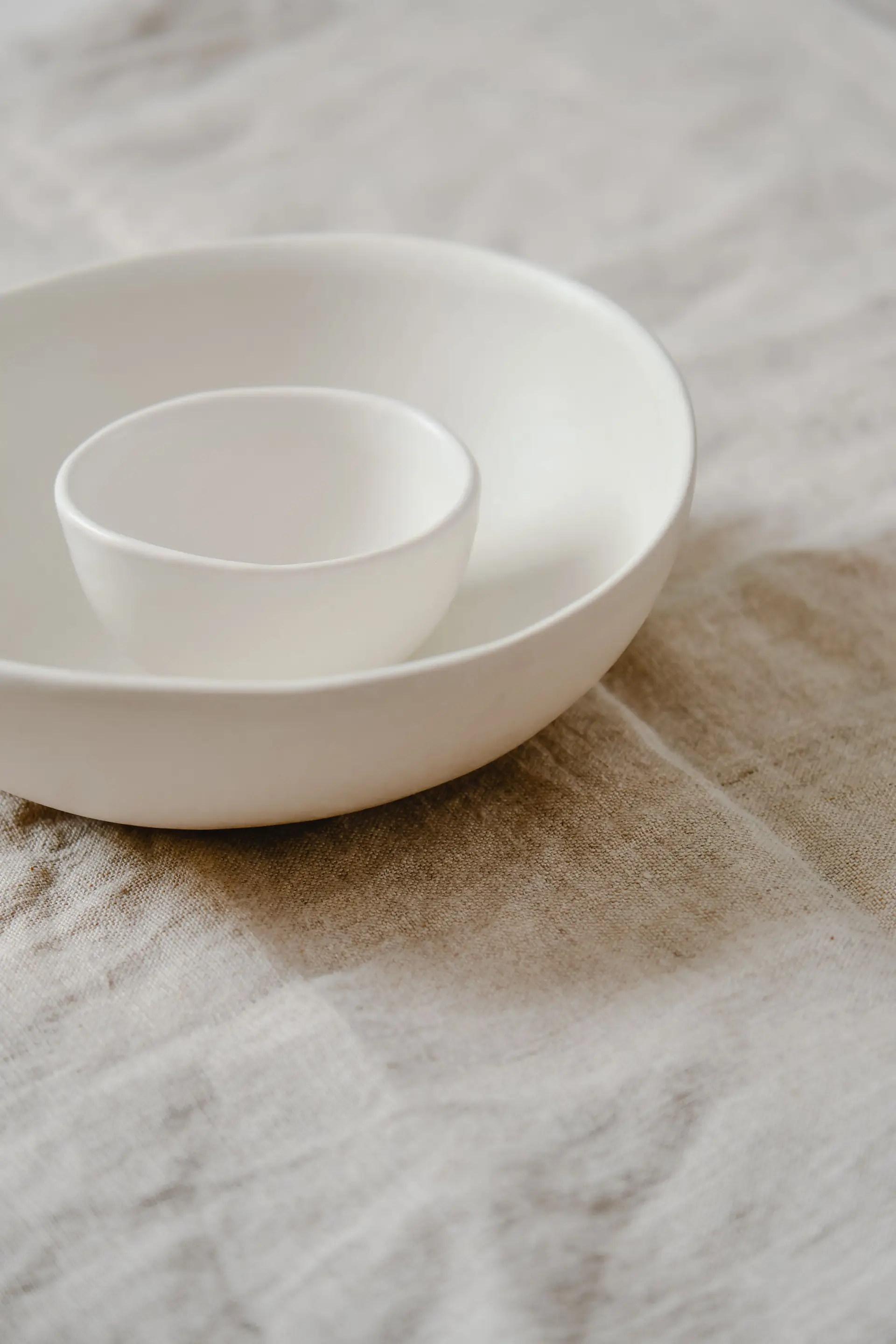 Keraamisia minimalistisia kulhoja luonnollisella pellavapinnalla